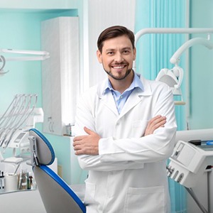 a dentist smiling while standing in the examination room