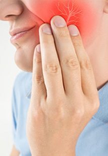 a person holding their cheek due to tooth pain